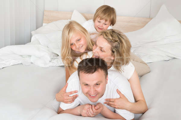 Jonge familie samen bed home kinderen Stockfoto © AndreyPopov