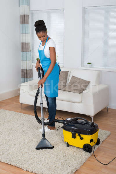 [[stock_photo]]: Femme · nettoyage · tapis · aspirateur · souriant · jeunes