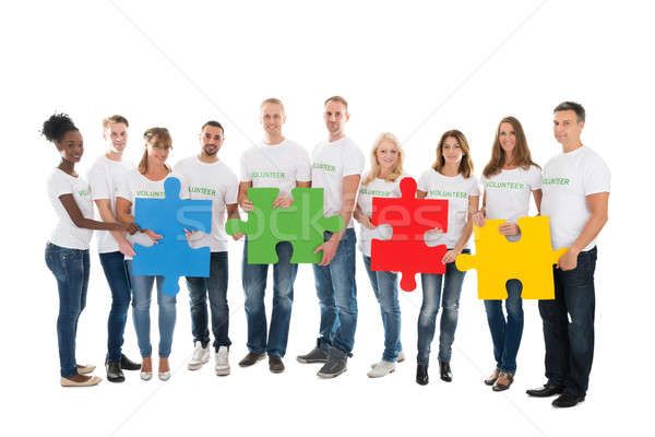 Portrait Of Confident Volunteers Holding Jigsaw Pieces Stock photo © AndreyPopov