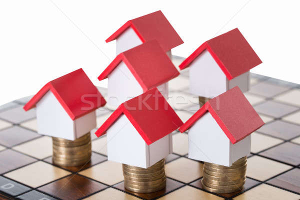 Ház modellek egymásra pakolva érmék sakktábla fehér Stock fotó © AndreyPopov