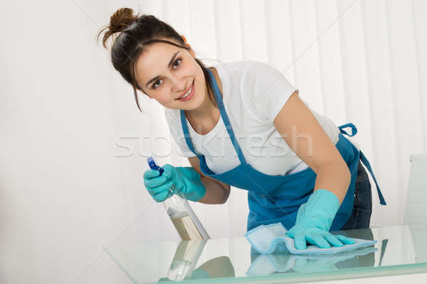 Young Female Janitor Cleaning Desk With Rag Stock photo © AndreyPopov