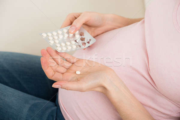 Pregnant Woman Taking Vitamin Pill Stock photo © AndreyPopov