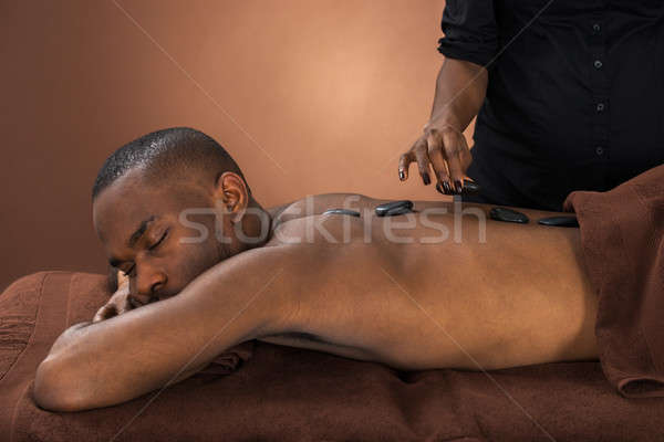 Man Getting Hot Stone Therapy Stock photo © AndreyPopov