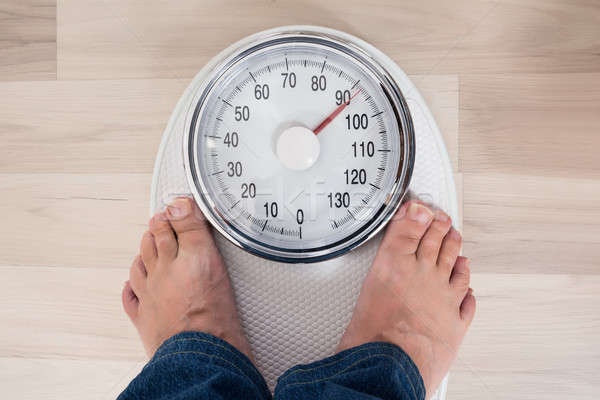 Person Standing On Weighing Scale Stock photo © AndreyPopov