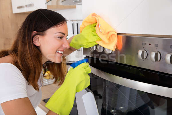 Mulher limpeza forno cozinha jovem feliz Foto stock © AndreyPopov