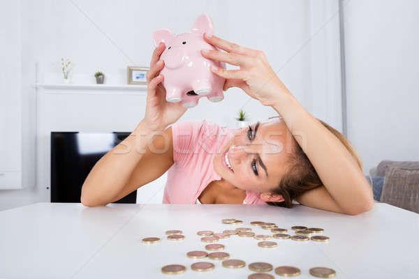 Happy Woman Emptying Her Piggybank Savings Stock photo © AndreyPopov