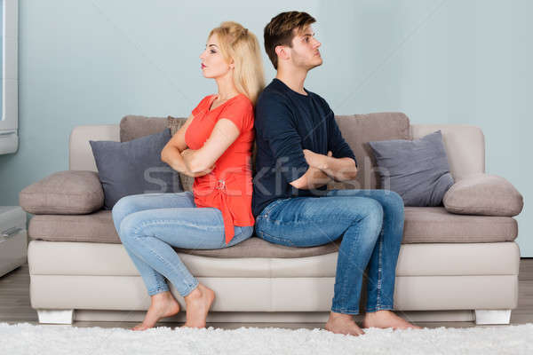 Unhappy Couple With Arms Crossed Sitting On Sofa Stock photo © AndreyPopov