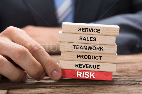 Businessman Holding Red Risk Block Under Wooden Tower Stock photo © AndreyPopov
