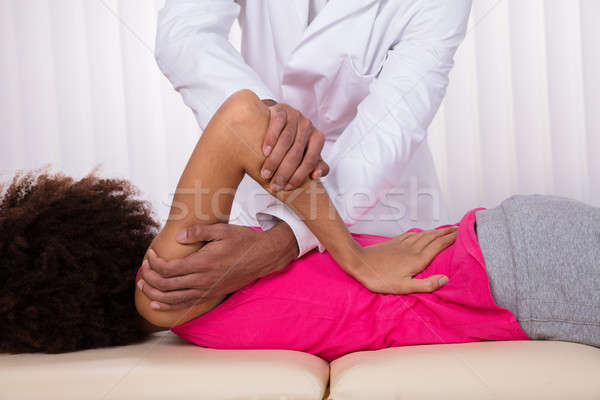 Physiotherapist Stretching Female Patient Shoulder Stock photo © AndreyPopov