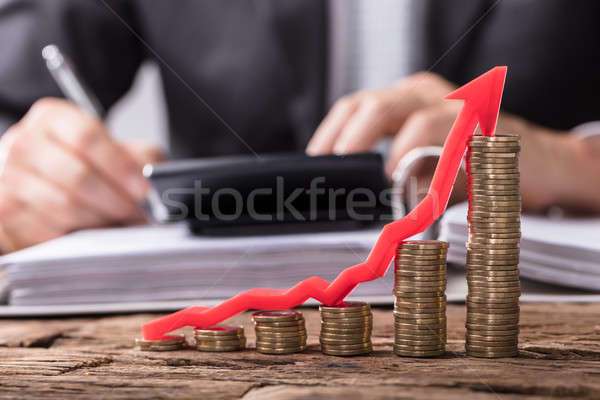 Increasing Golden Coins With Red Arrow Showing Upward Direction Stock photo © AndreyPopov