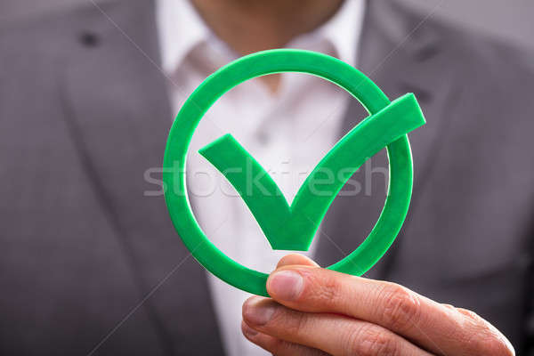 Businessperson Holding Check Mark Icon Stock photo © AndreyPopov