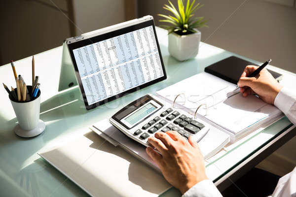 Businessman calculating invoice using calculator Stock photo © AndreyPopov