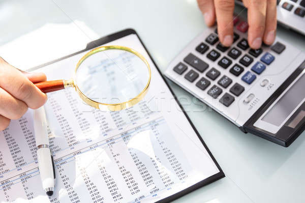 Businessman Analyzing Financial Report With Magnifying Glass Stock photo © AndreyPopov