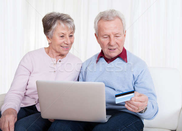 Foto stock: Pareja · de · ancianos · compras · línea · sesión · sofá · ordenador · portátil