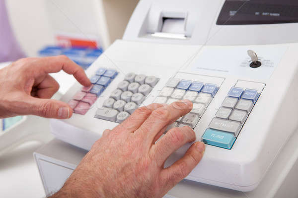 Sales person entering amount on cash register Stock photo © AndreyPopov