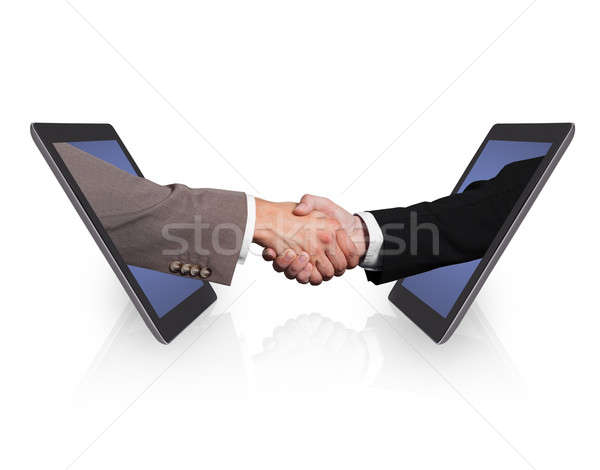 Business Handshake Emerging From Digital Tablets Stock photo © AndreyPopov