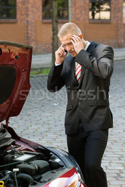 Stressed Young Man With His Breakdown Car Calling On Cellphone Stock photo © AndreyPopov