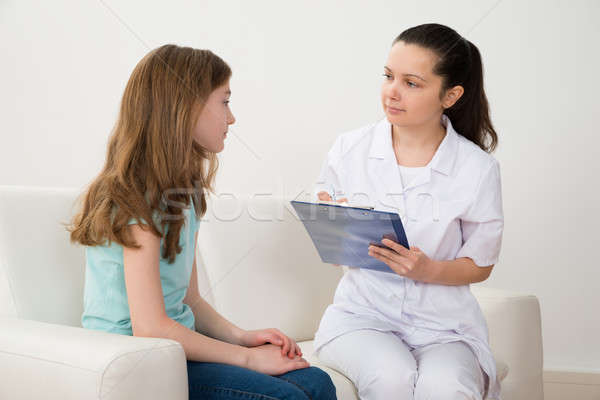 Doctor And Patient With Clipboard On Sofa Stock photo © AndreyPopov