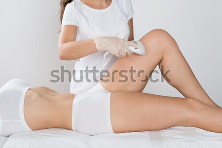 Midsection Of Beautician Using Laser Machine On Customer's Leg Stock photo © AndreyPopov