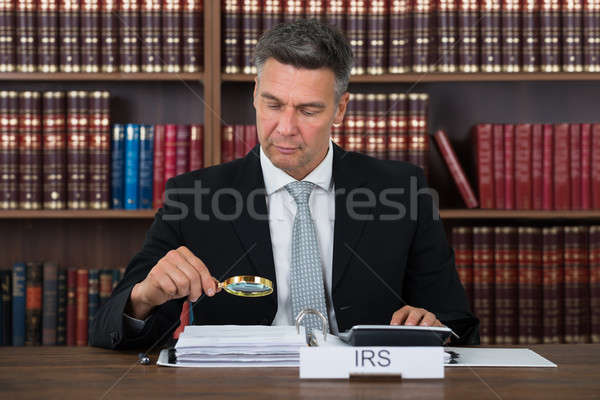 Könyvvizsgáló megvizsgál iratok nagyító asztal érett Stock fotó © AndreyPopov