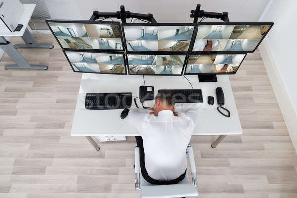 Male Operator Sleeping While Leaning On Security Monitor's Desk Stock photo © AndreyPopov