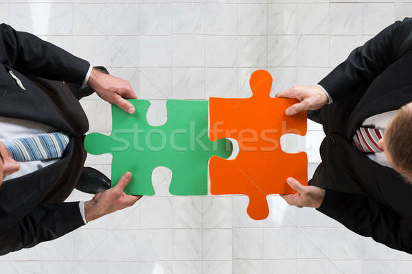 Businessmen Assembling Jigsaw Puzzle Representing Teamwork Stock photo © AndreyPopov