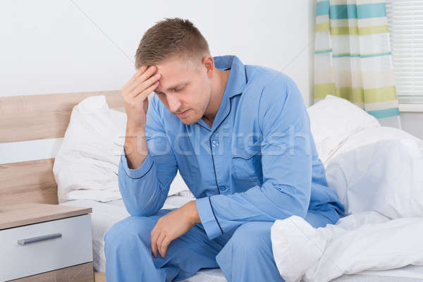 Mann Leiden Kopfschmerzen Sitzung Bett Stock foto © AndreyPopov