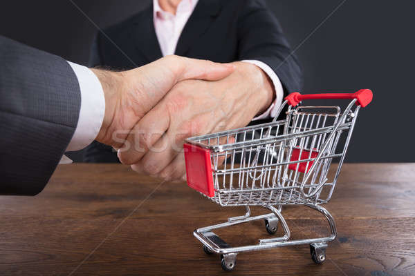 Two Businessmen Shaking Hands Near Shopping Cart Stock photo © AndreyPopov