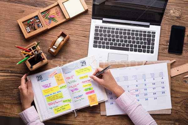 Businesswoman Writing Schedule In Calendar Diary Stock photo © AndreyPopov