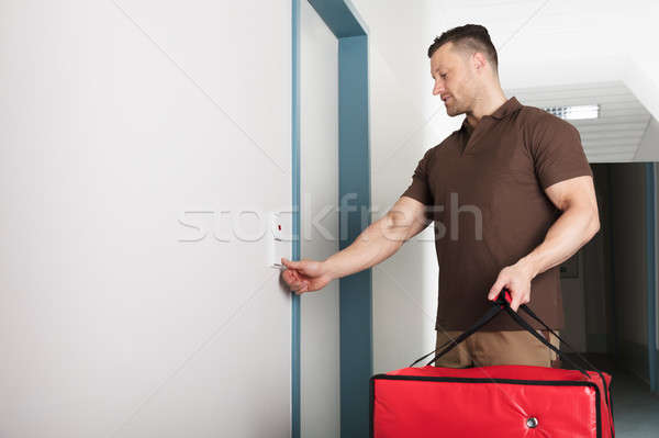 Young Pizza Delivery Man Ringing The Door Bell Stock photo © AndreyPopov
