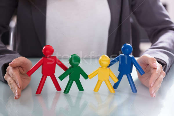 Businesswoman Protecting Human Figures Stock photo © AndreyPopov