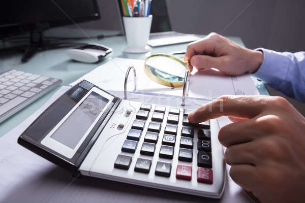 Stock photo: Businessperson Using Calculator For Calculating Bill