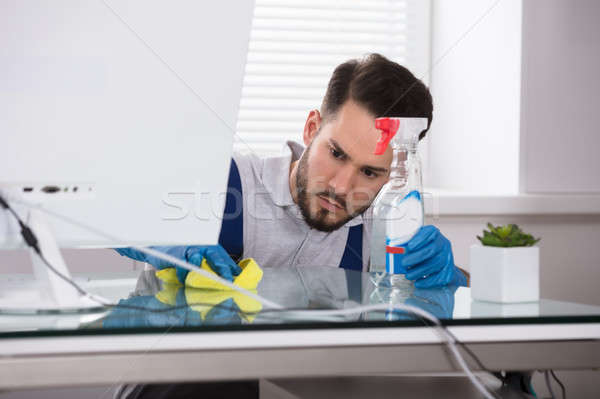 Janitor Cleaning Desk In Office Stock photo © AndreyPopov