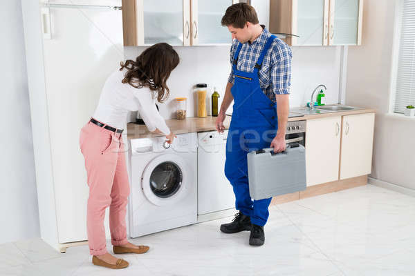 Woman Showing Damage In Washing Machine To Repairman Stock photo © AndreyPopov