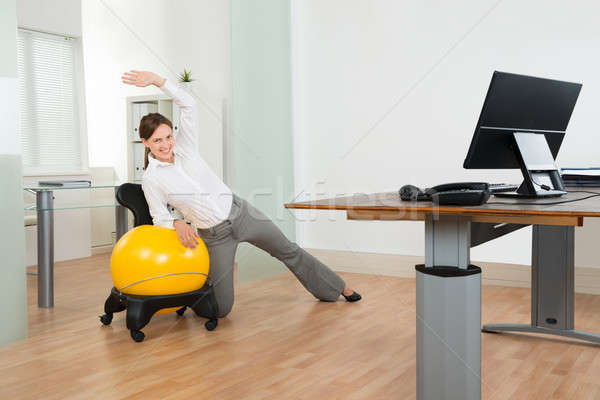 Businesswoman Doing Fitness Exercise On Pilates Ball Stock photo © AndreyPopov