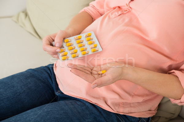 Pregnant Woman Taking Vitamin Pill At Home Stock photo © AndreyPopov