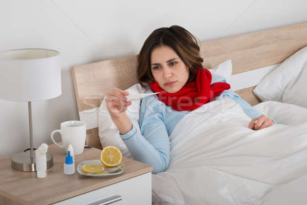 Bolnav femeie uita termometru pat iarnă Imagine de stoc © AndreyPopov