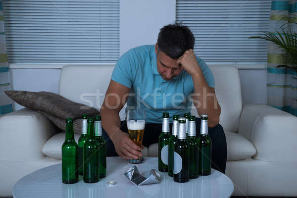 Man Sitting On Sofa In Front Of Beer During Night Stock photo © AndreyPopov