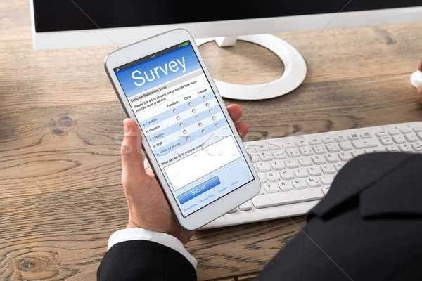 Close-up Of A Businessman Filling Online Survey Form Stock photo © AndreyPopov