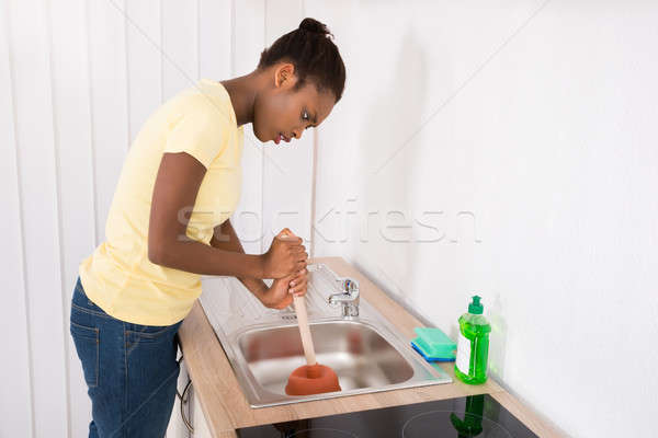 Woman Using Plunger In Sink Stock photo © AndreyPopov