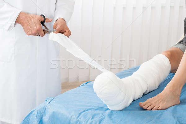 Close-up Of Doctor Bandaging Leg Of Patient Stock photo © AndreyPopov