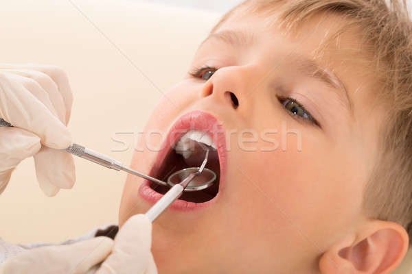 Dentist's Hand Examining Teeth Of Child Patient Stock photo © AndreyPopov