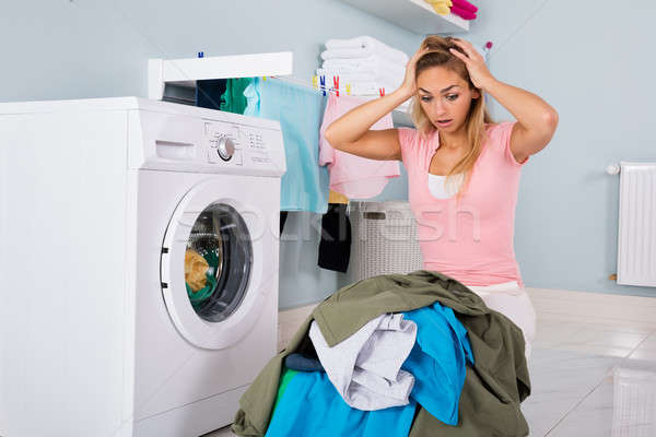 Infeliz mujer mirando ropa utilidad habitación Foto stock © AndreyPopov