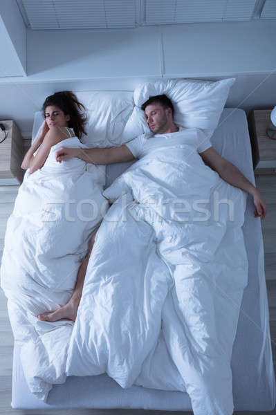 Young Couple Sleeping On Bed Stock photo © AndreyPopov