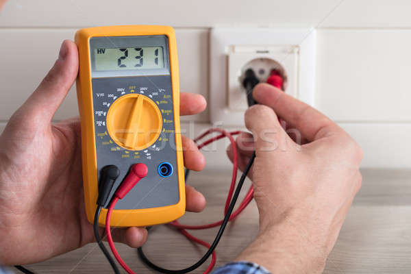 Male Electrician Checking Voltage Of Socket With Multimeter Stock photo © AndreyPopov