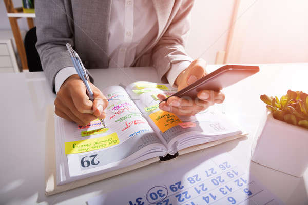 Person Hands With Mobile Phone And List Of Work Stock photo © AndreyPopov