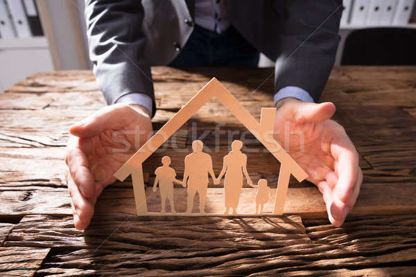 Businessperson Protecting House Model And Family Paper Cut Out Stock photo © AndreyPopov