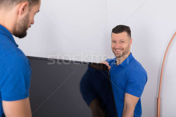 Two Movers Placing Television In Living Room Stock photo © AndreyPopov