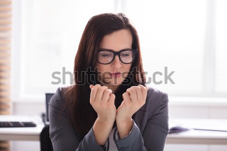 Businesswoman Looking At Her Finger Nails Stock photo © AndreyPopov