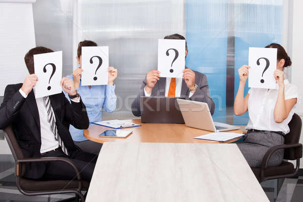 Geschäftsleute halten Fragezeichen Zeichen Gruppe Sitzung Stock foto © AndreyPopov